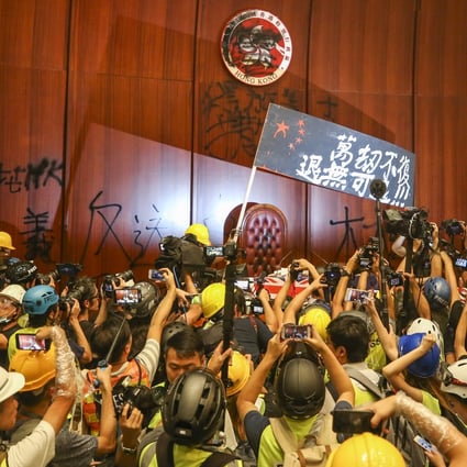 Protesters storm the legislature on July 1 as reporters rush to take pictures of the unprecedented event. Photo: Winson Wong