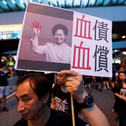 A protester holds a placard criticising Hong Kong Chief Executive Carrie Lam during a march on June 16. Photo: Reuters