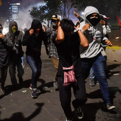 Indonesian students run from police shooting tear gas during a protest outside the parliament building in Jakarta in September 2019. Photo: AFP