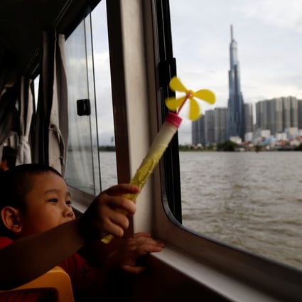 A boy inside a Saigon water bus with Vietnam’s tallest building Landmark 81 in the background in Ho Chi Minh City on June 6, 2019. Photo: Reuters