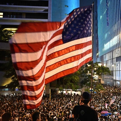 A man waves an American flag at a protest rally in Hong Kong on Monday as demonstrators called on US lawmakers to pass the Hong Kong Human Rights and Democracy Act of 2019. Photo: AFP