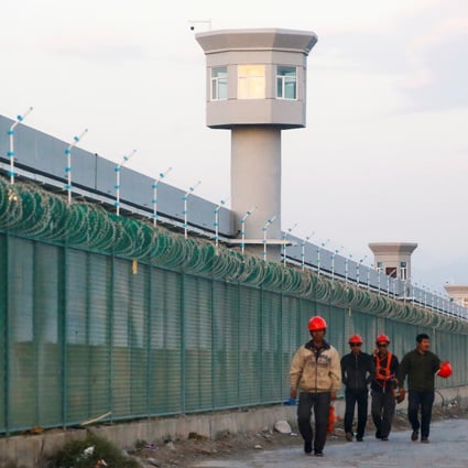 Workers walk by the perimeter fence of what is officially known as a vocational skills education centre in Dabancheng in Xinjiang Uygur autonomous region. Photo: Reuters