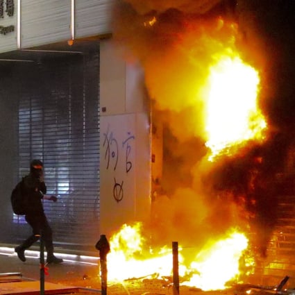Masked anti-government protesters set stores on fire. Photo: May Tse