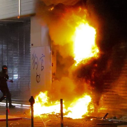 A shop selling smartphones made by Chinese company Xiaomi was torched by hard-core protesters, before a thief took advantage of the chaos. Photo: Felix Wong