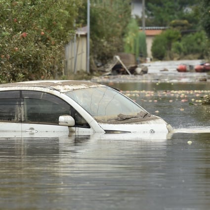 A man in Nagano wades through floodwaters in the aftermath of Typhoon Hagibis. Photo: AFP