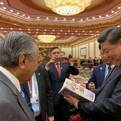 Chinese President Xi Jinping reads the controversial belt and road comic as Malaysian Prime Minister Mahathir Mohamad looks on. Photo: Facebook/Hew Kuan Yau