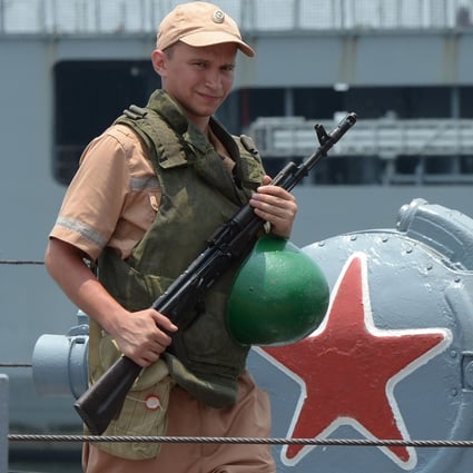 An armed sailor stands guard on a Russian aircraft carrier during a visit to Manila in 2017. Photo: AFP