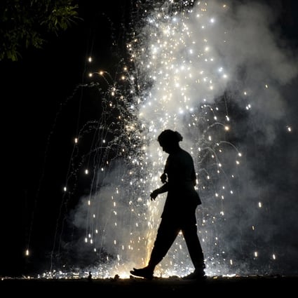 A woman is silhouetted by lit firecrackers during Diwali celebrations in Chennai. Photo: AFP