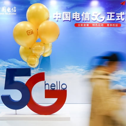 A consumer walks past a poster promoting 5G mobile applications outside a branch of China Telecom in Beijing on October 31. Photo: Xinhua