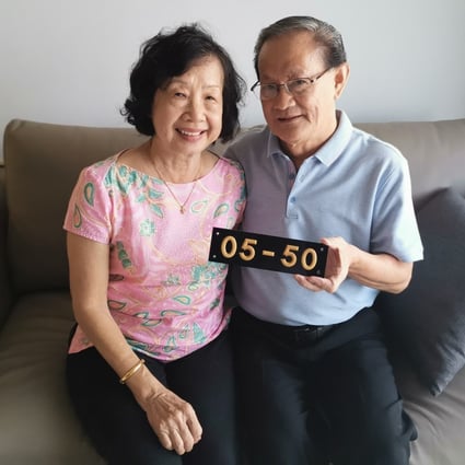 The Chungs with their old unit number from Shunfu Ville, at their new place in Sengkang. Photo: Derek Wong