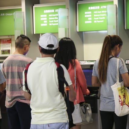 People queue up at the ATM in Central. Photo: David Wong