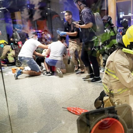 A firefighter attends to the suspected attacker while others help those injured in the incident. Photo: Edmond So