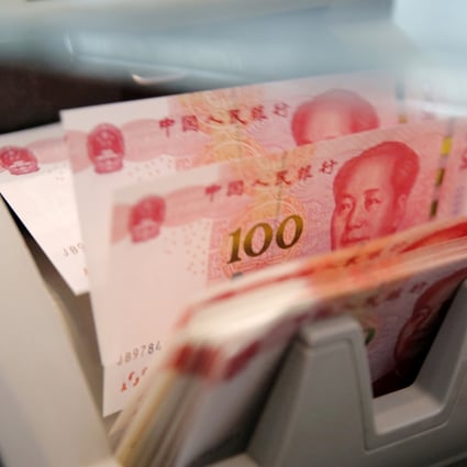 Chinese 100 yuan banknotes are seen in a counting machine while a clerk counts them at a branch of a commercial bank in Beijing, China. Photo: Reuters