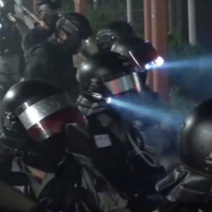 Riot police officers gathered on a bridge in Tuen Mun were filmed taunting protesters below, with one saying they would celebrate the death of a student. Photo: Cable TV