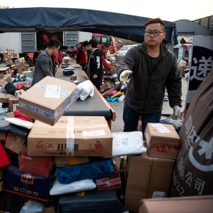 Workers sort out packages at a delivery company warehouse to be delivered to customers on November 12, the day after Singles’ Day. Photo: AFP