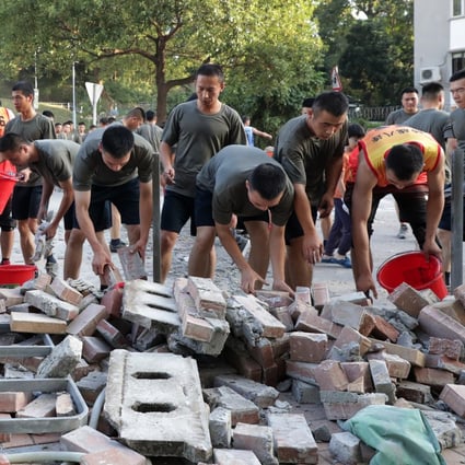 Soldiers from the PLA help clear roadblocks outside Baptist University. Photo: Edmond So