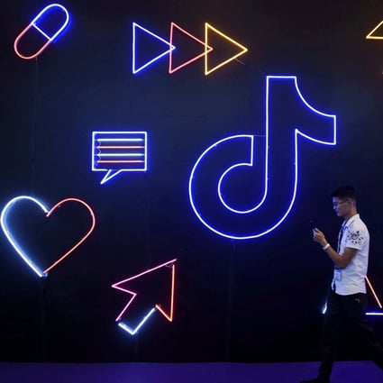 A man holding a phone walks past a sign of Chinese company ByteDance's app TikTok, known locally as Douyin, in Hangzhou, China. Photo: Reuters
