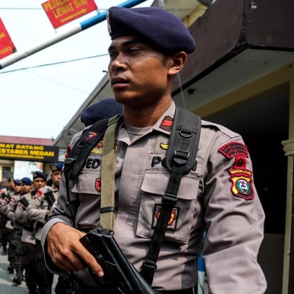 Police officers stand guard at the scene of the suicide bombing at Medan city police headquarters. Photo: EPA
