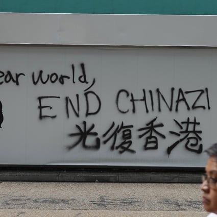 A man walks past a wall spray-painted with an anti-China message on October 7. Photo: AP