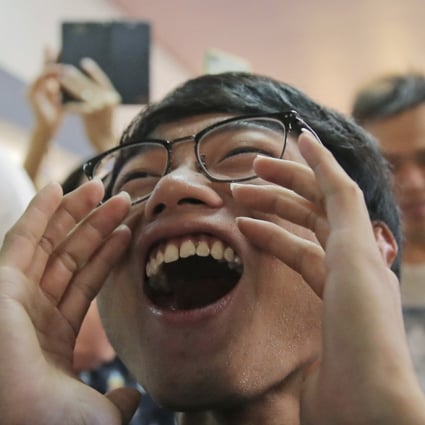 Pro-democracy supporters celebrate after a pro-Beijing politician loses his bid for a district council seat in Hong Kong early Monday. Photo: AP