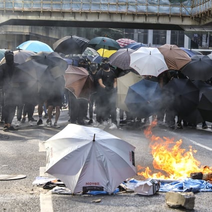 Anti-government protesters set barricades on fire during a lunchtime rally in Central, Hong Kong on November 12. Photo: K. Y. Cheng