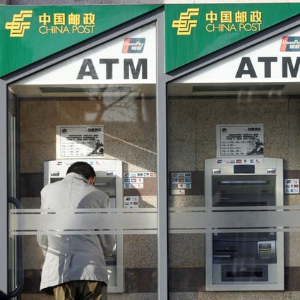 Customers at the China Postal Savings Bank's ATMs in Beijing on 3 February 2007. Photo: AFP