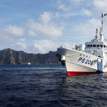 A Japan Coast Guard vessel sails in front of one of the disputed islands in 2013. Photo: Reuters