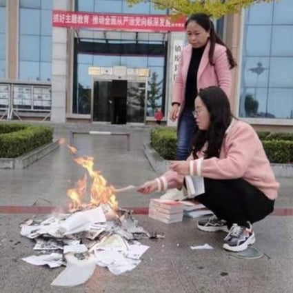 The report included a photo of two employees burning books in front of the public library in Zhenyuan, Gansu province. Photo: Handout