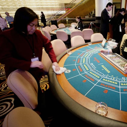 A cleaner wipes down a gambling table just before the opening of the new Sands Casino in Macau on 18 May 2004. Sands is the first American operator of gambling facilities in the Chinese Special Administrative Region (SAR). Photo: AFP
