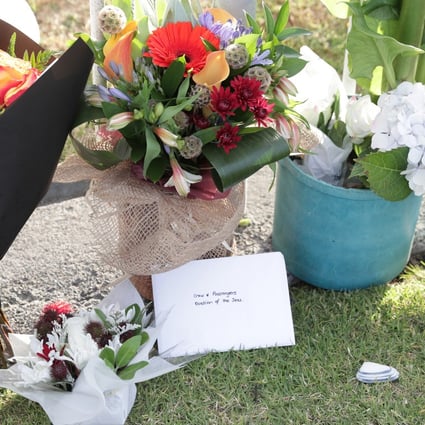 Floral tributes to the volcano’s victims lie at the port in Tauranga, where the cruise ship Ovation of the Seas is berthed. Photo: EPA