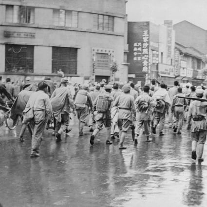 Disarmed Nationalist troops march down Nanking Road, the main street, under guard of Communist troops during the latter’s takeover of China. Photo: Getty Images
