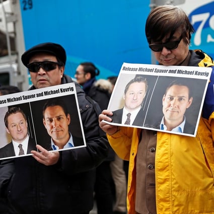 People hold placards calling for China to release Michael Spavor and Michael Kovrig outside a court hearing for Huawei executive Meng Wanzhou in Vancouver in March. Photo: Reuters