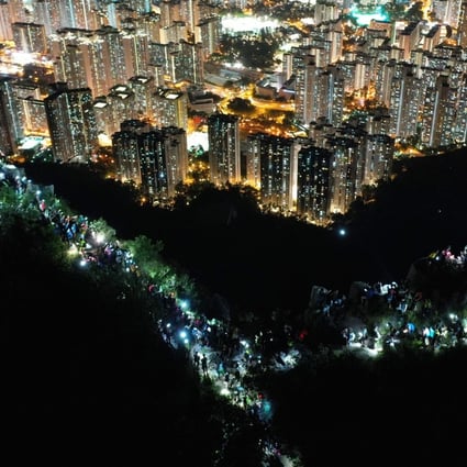 Protesters in Hong Kong shine their mobile phone torches as they form a human chain at the top of Lion Rock Hill, during a rally on August 23. Photo: Winson Wong