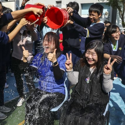Vice-principal Chan Wai-wa (left) and principal Cecilia Tang get drenched. Photo: Dickson Lee