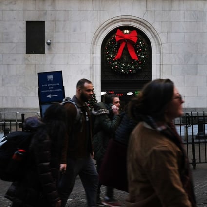 People walk by the New York Stock Exchange at the beginning of the Christmas holiday week on December 23. Aggressive monetary policy easing by central banks around the world over the past year had a huge impact on asset returns, squeezing up valuations on stocks, credit and bonds alike. Photo: Getty Images / AFP