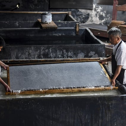 Cao Jianqin (R) makes Xuan paper at the Zijinlou Xuan paper factory in Jingxian County in eastern China's Anhui Province on October 22, 2019. Xuan paper, traditional Chinese paper made in Jingxian County of Xuancheng City, has a history of more than 1,000 years. Photo: Xinhua