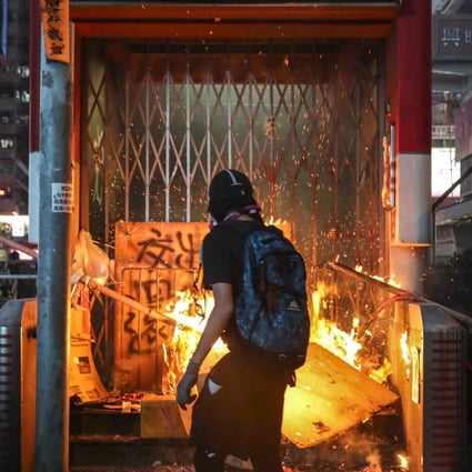 An anti-government protester sets fire to an entrance of Mong Kok MTR station during an illegal rally in October. Photo: Edmond So