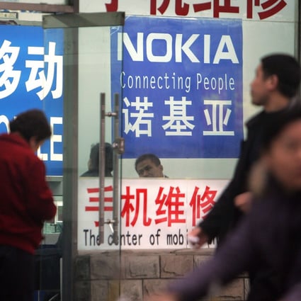 Pedestrians pass a shop selling mobile phones in Beijing, April 1, 2007. The ubiquity of mobile apps was built on the popularity of smartphones, which signalled a new era when the Android operating system overtook Nokia’s Symbian in 2012. Photo: AFP