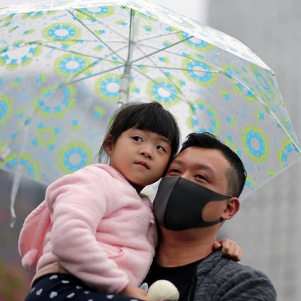 A demonstrator with a child attends an anti-government rally at Edinburgh Place on December 29. Photo: Reuters