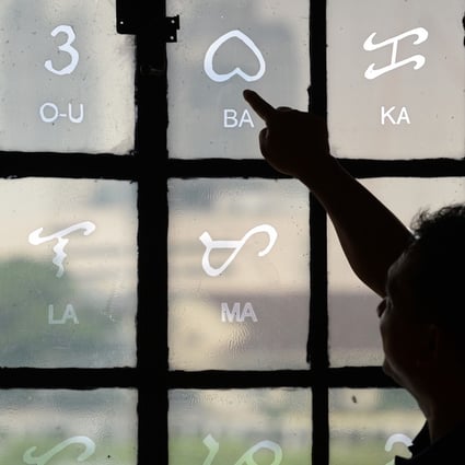 Baybayin characters etched on a glass window at the National Museum in Manila. The pre-colonial script is undergoing a revival of sorts, and an enthusiast’s card game is helping spread the word about it. Photo: Ted Aljibe/AFP