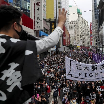 A protesters holds up a hand, to symbolise the movement’s five demands, during a march on New Year’s Day in Causeway Bay. The five demands include democratic elections for Hong Kong’s leader and legislature, and a probe into police behaviour during the six months of protests. Photo: Sam Tsang