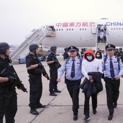 Police escort criminal suspects as they get off a plane in Beijing, Friday, June, 7, 2019. A group of 94 Taiwanese accused of telephone and online fraud arrived at Beijing airport after being extradited from Spain, Chinese authorities said. Photo: Xinhua via AP
