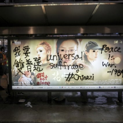 Anti-government slogans are seen on an advertising board at a bus stop in Hong Kong. Photo: EPA-EFE