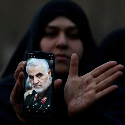 An Iranian woman shows a photo of the late Major General Qassem Soleimani during a protest against his assassination by the US. Photo: Reuters