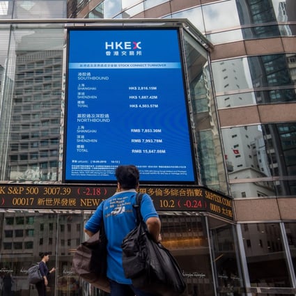 A pedestrian stands in front of an electronic ticker board and a screen displaying stock figures outside the Exchange Square complex, which houses the Hong Kong stock exchange, in Hong Kong on Monday, September 16, 2019. Photo: Bloomberg