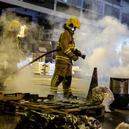 A firefighter puts out a fire started by protesters in Kowloon on December 31. Photo: AFP
