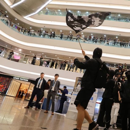 Black-clad, chanting protesters stage a demonstration at the Times Square shopping mall in Causeway Bay on Christmas Day. Photo: May Tse