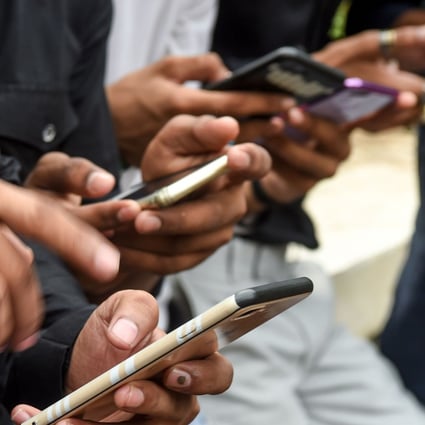 In this photo taken on November 10, 2019, youngsters watch videos on the TikTok, the popular video-sharing app from ByteDance, on their smartphones in Mumbai. Photo: Agence France-Presse
