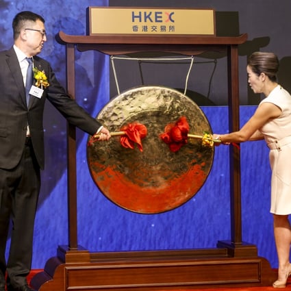 Jiumaojiu chairman Guan Yihong (left) and his wife Yang Sanyin strike the ceremonial gong to mark the company’s trading debut on the Hong Kong stock exchange on Wednesday. Photo: Jonathan Wong
