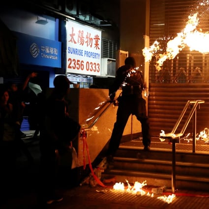 An anti-government protester throws a petrol bomb at Hung Hom MTR station during a rally on December 1. Photo: Reuters